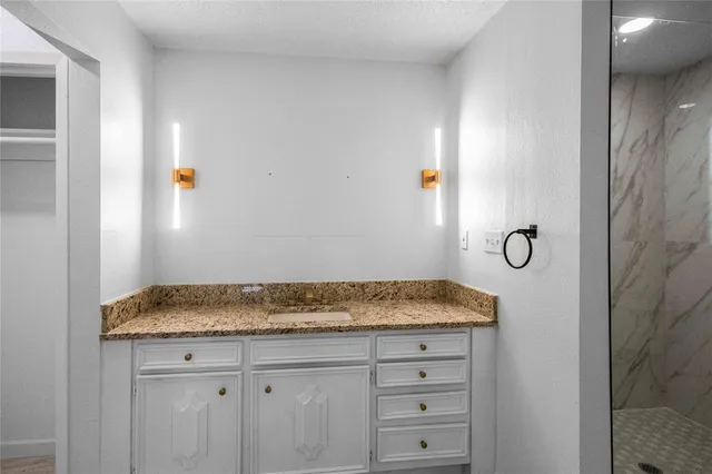 a bathroom with a granite countertop sink and vanity