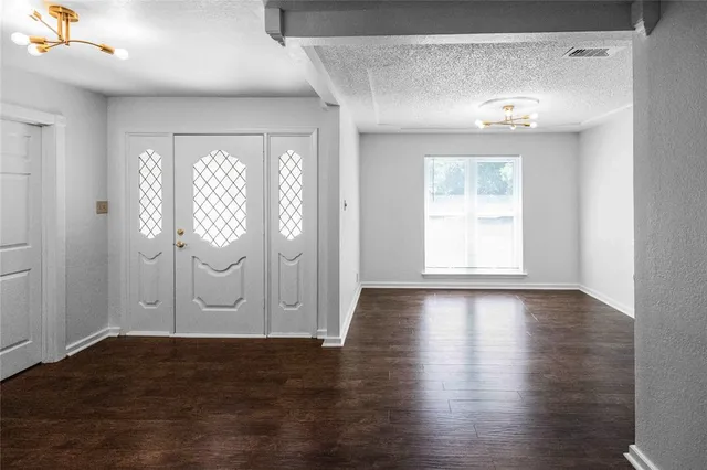 an empty room with wooden floor and window