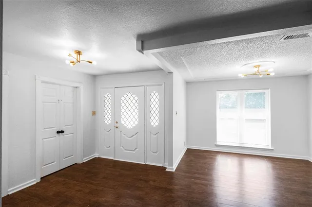 an empty room with wooden floor and window
