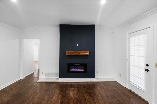 a living room with wooden floor and a fireplace
