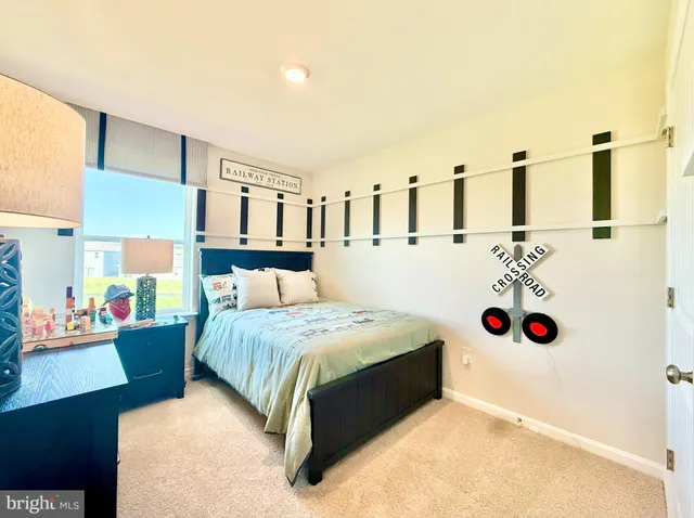 a bedroom with a bed table and a large mirror