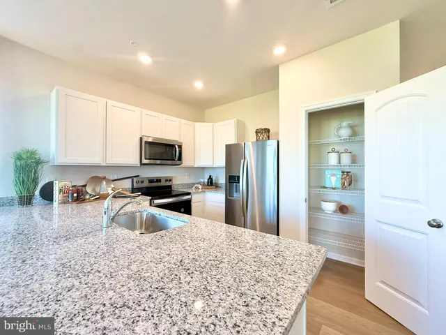 a kitchen with stainless steel appliances granite countertop a refrigerator stove top oven a sink and dishwasher