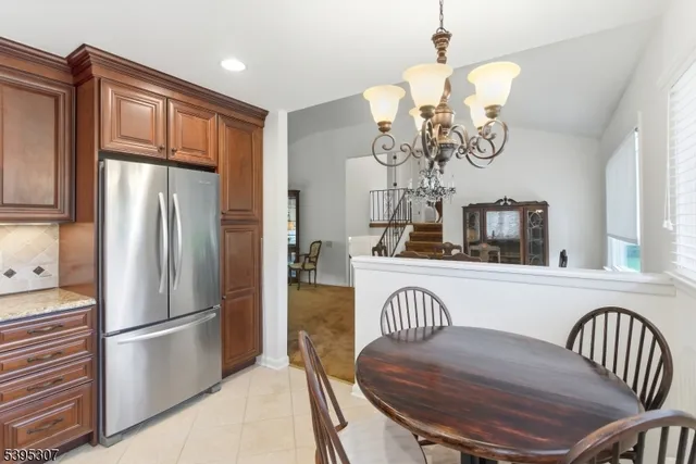 a view of kitchen with furniture stainless steel appliances wooden floor and a chandelier