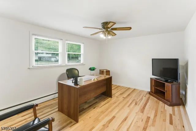 a view of a workspace with furniture and a window