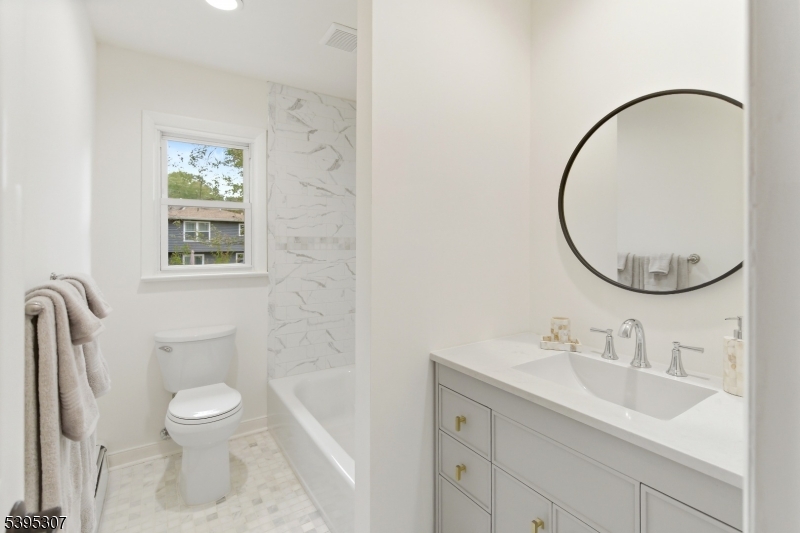 2286 Stocker Lane Scotch Plains, NJ 07076 - Photo 22 of 27 a bathroom with a toilet sink a mirror and a window