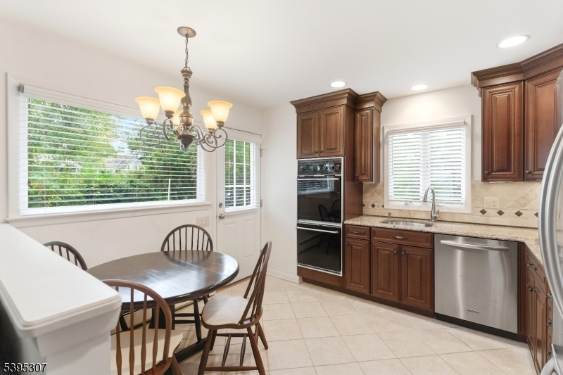 2286 Stocker Lane Scotch Plains, NJ 07076 - Photo 9 of 27 a kitchen with stainless steel appliances granite countertop a sink a stove a kitchen island with chairs and cabinets