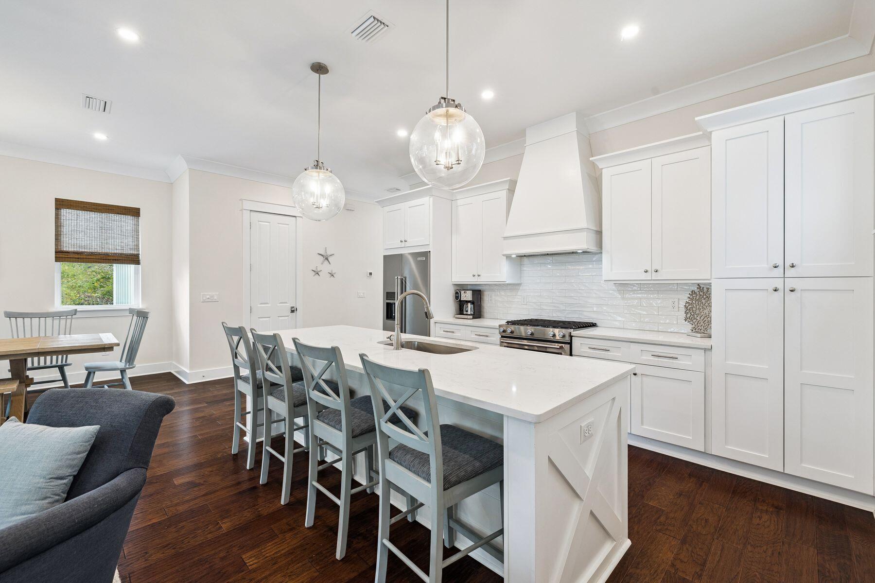 421 Gulfview Circle Santa Rosa Beach, FL 32459 - Photo 6 of 34 a kitchen with a dining table chairs stainless steel appliances and cabinets