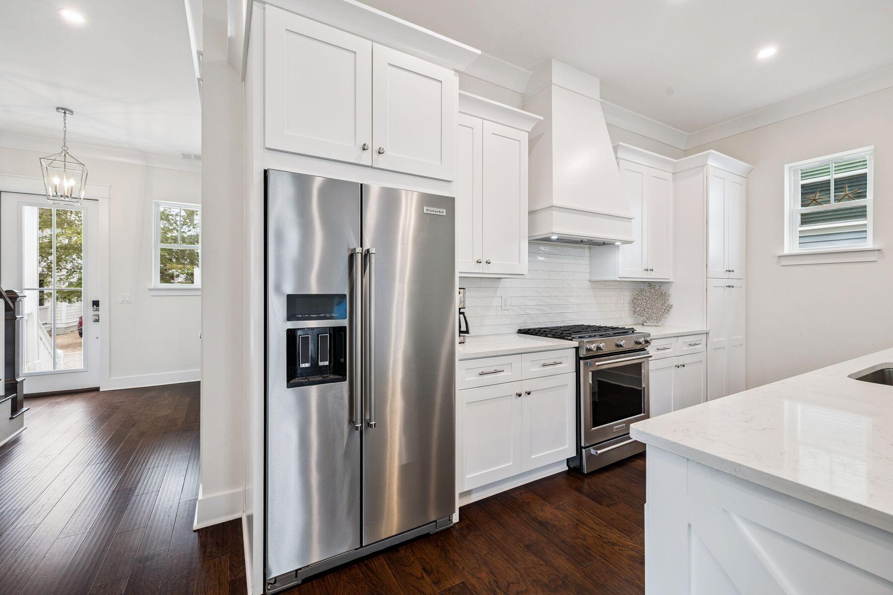421 Gulfview Circle Santa Rosa Beach, FL 32459 - Photo 7 of 34 a kitchen with stainless steel appliances a refrigerator a stove a sink and white cabinets with wooden floor