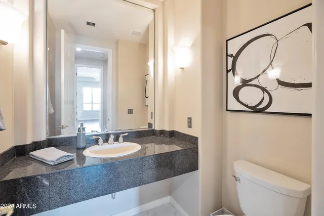a bathroom with a granite countertop sink and a mirror