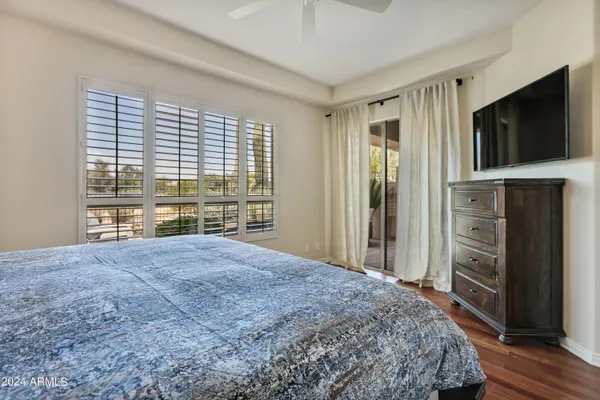 a view of bedroom with wooden floor and a flat screen tv