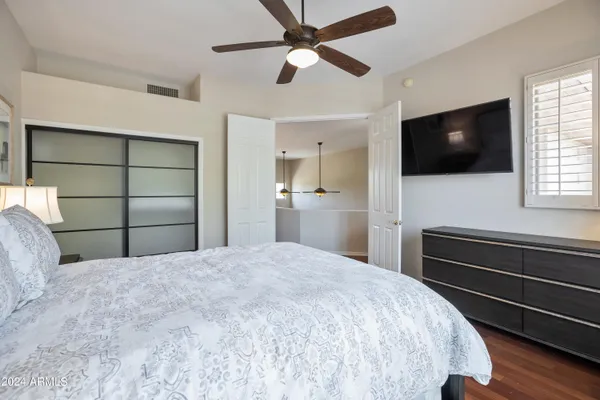 a bedroom with a bed and a flat screen tv