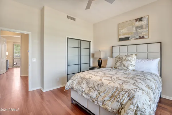 a bedroom with a bed and wooden floor
