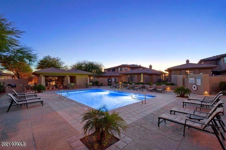 15240 North Clubgate Drive, Unit 150 Scottsdale, AZ 85254 - Photo 35 of 42 a patio with a table and chairs under an umbrella
