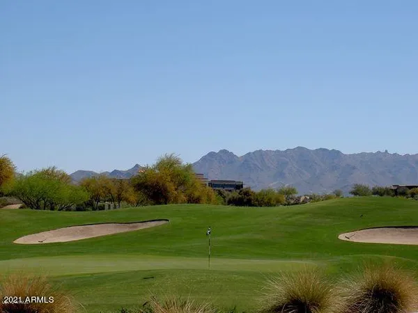 a view of a grassy field with mountains in the background