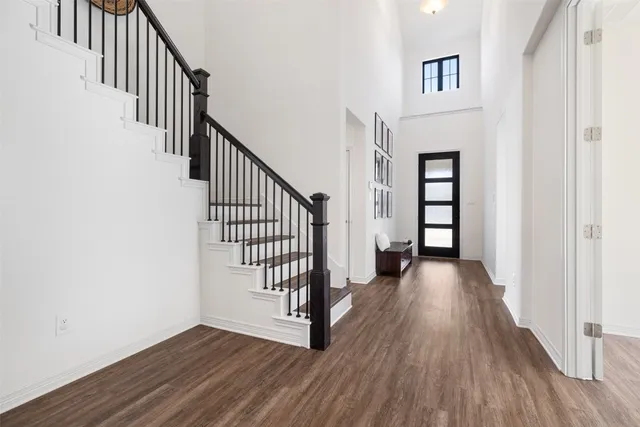 a view of a livingroom with wooden floor and stairs