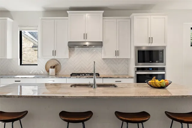 a kitchen with stainless steel appliances a sink and a stove