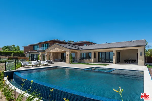 a front view of a house with swimming pool having outdoor seating