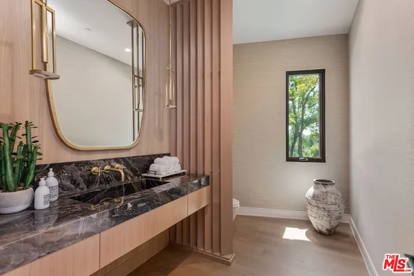 a bathroom with a granite countertop sink and a mirror