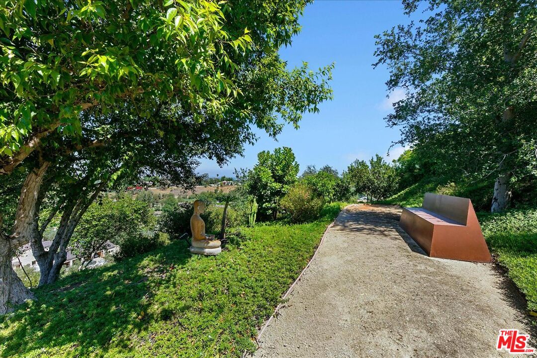 5757 Hoback Glen Road Hidden Hills, CA 91302 - Photo 12 of 41 a backyard of a house with fountain plants and large tree