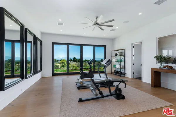 a living room with furniture floor to ceiling window and wooden floor