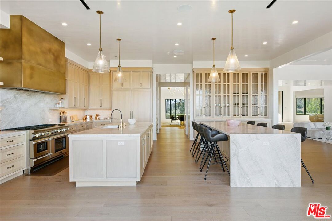5757 Hoback Glen Road Hidden Hills, CA 91302 - Photo 19 of 41 a large kitchen with a large counter top a sink stainless steel appliances and cabinets