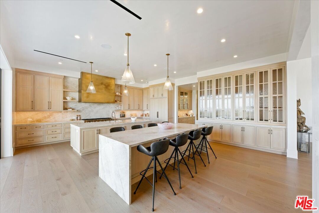 5757 Hoback Glen Road Hidden Hills, CA 91302 - Photo 20 of 41 a kitchen with stainless steel appliances kitchen island granite countertop a stove a sink a refrigerator and white cabinets