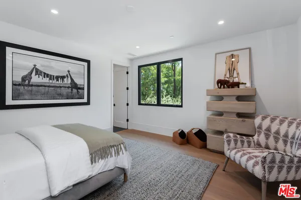 a spacious bedroom with a bed a couch and a large window