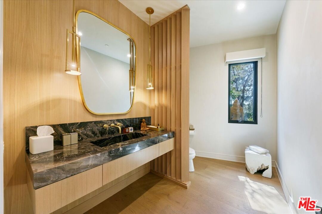5757 Hoback Glen Road Hidden Hills, CA 91302 - Photo 26 of 41 a bathroom with a granite countertop sink and a mirror