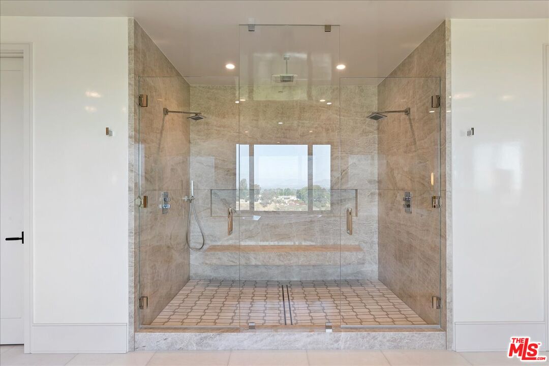 5757 Hoback Glen Road Hidden Hills, CA 91302 - Photo 31 of 41 a bathroom with a glass shower door and a sink