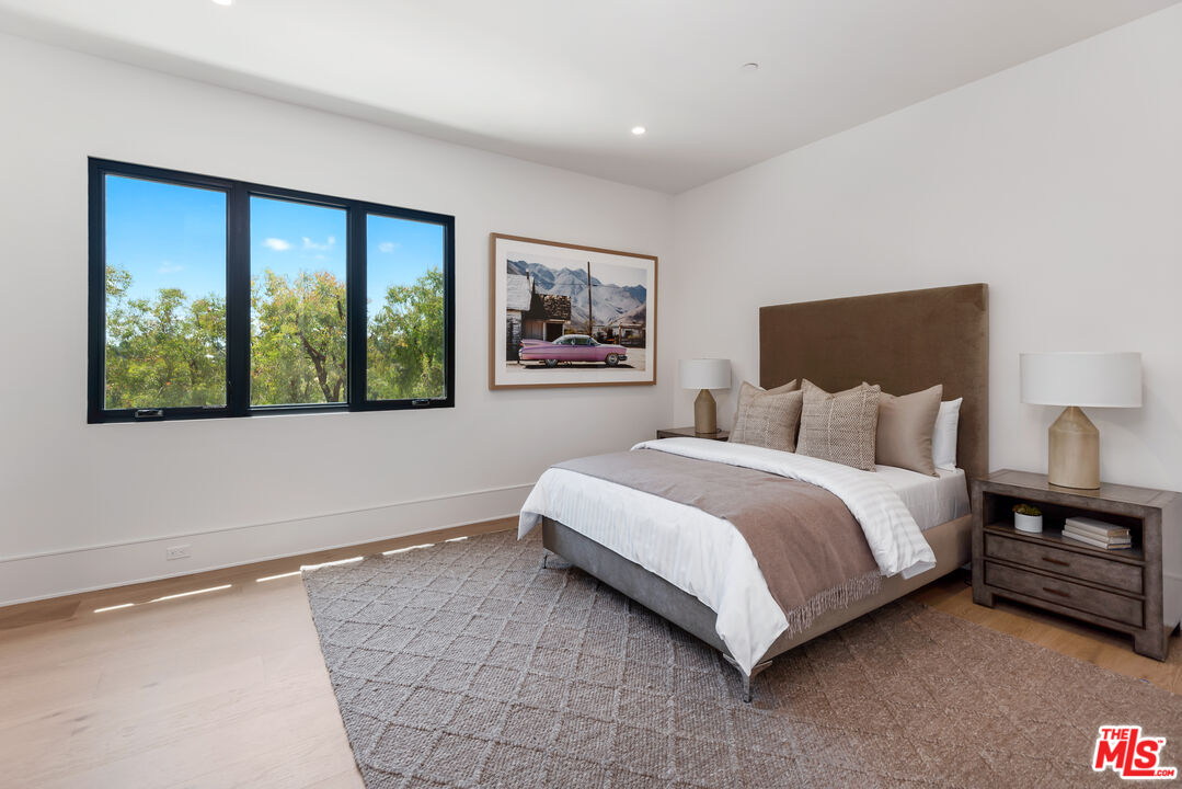 5757 Hoback Glen Road Hidden Hills, CA 91302 - Photo 35 of 41 a bedroom with a large bed and a large window