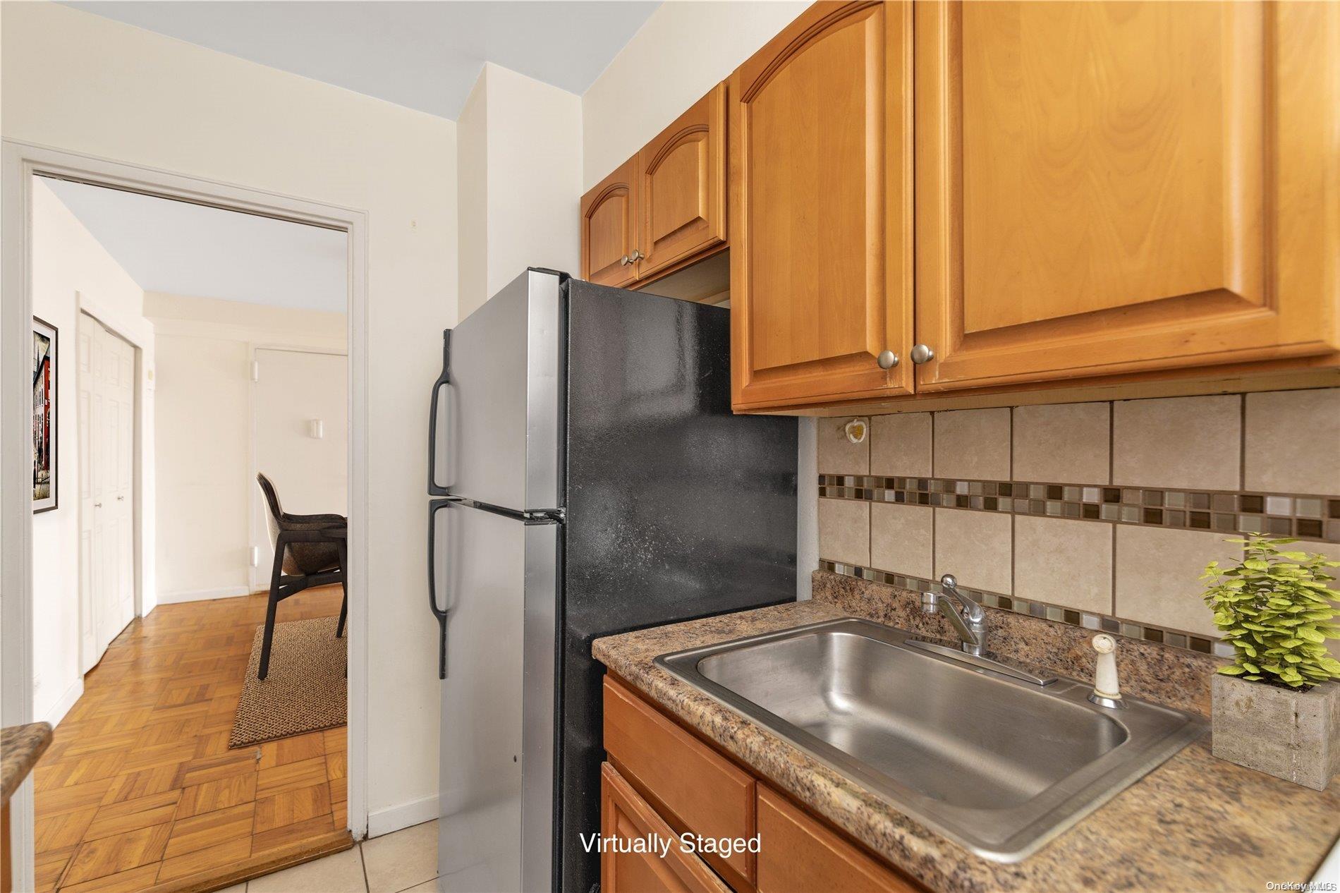 109-33 71st Road, Unit 7B Queens, NY 11375 - Photo 7 of 14 a kitchen with stainless steel appliances granite countertop a sink a refrigerator and a wooden cabinets