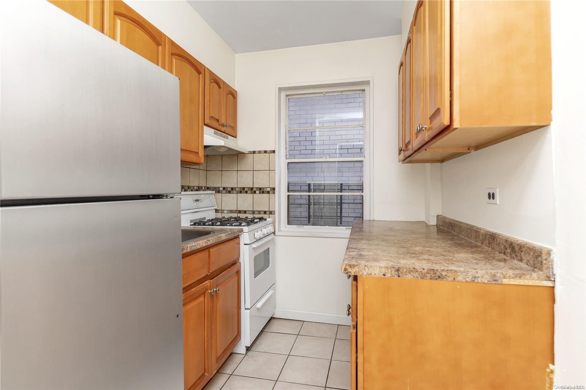 109-33 71st Road, Unit 7B Queens, NY 11375 - Photo 8 of 14 a kitchen with stainless steel appliances granite countertop a sink stove and refrigerator