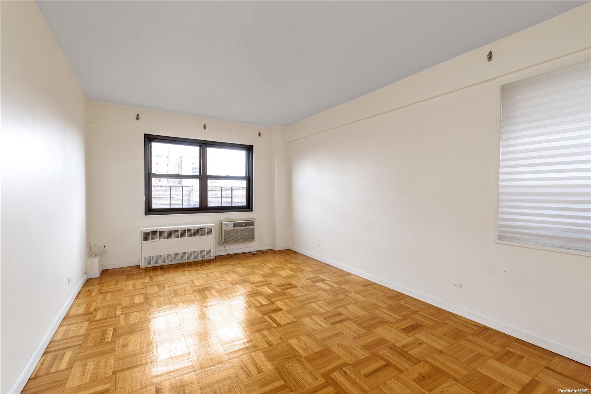 109-33 71st Road, Unit 7B Queens, NY 11375 - Photo 10 of 14 a view of a bedroom with wooden floor and windows