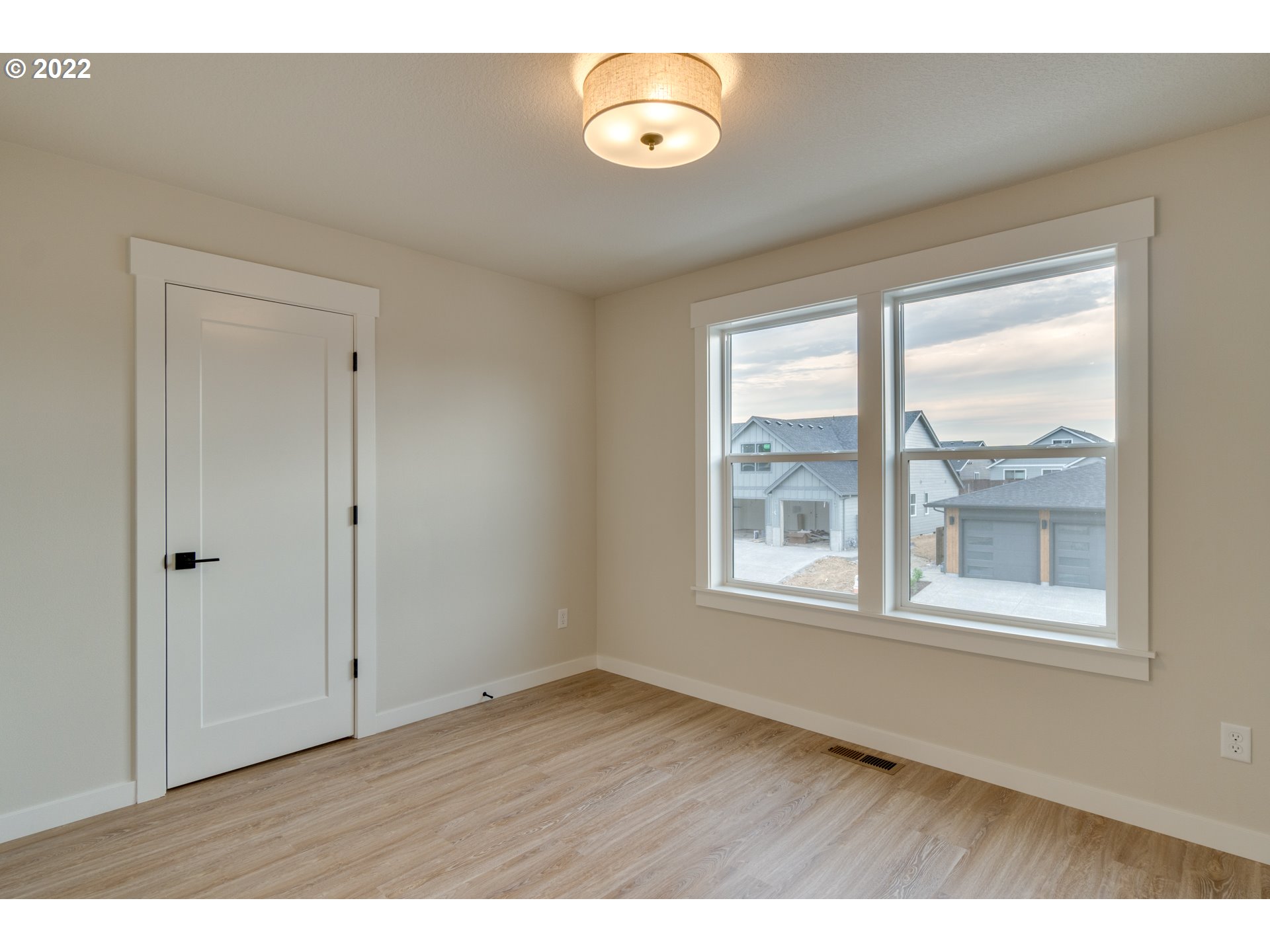 248 North 22nd Court Ridgefield, WA 98642 - Photo 8 of 15 a view of an empty room with wooden floor and windows