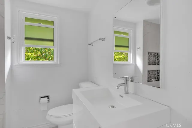 a white toilet sitting next to a bathroom sink