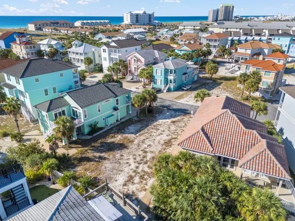 an aerial view of a house with a garden and painted chairs