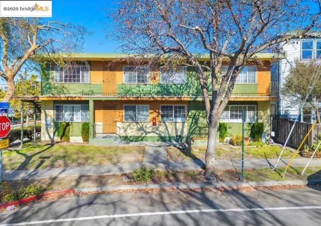 a view of a brick house with large windows and a small yard