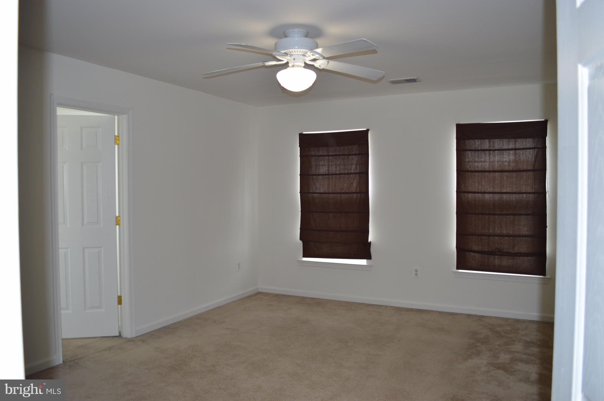 6500 Clarington Road Baltimore, MD 21209 - Photo 20 of 30 an empty room with windows and ceiling fan