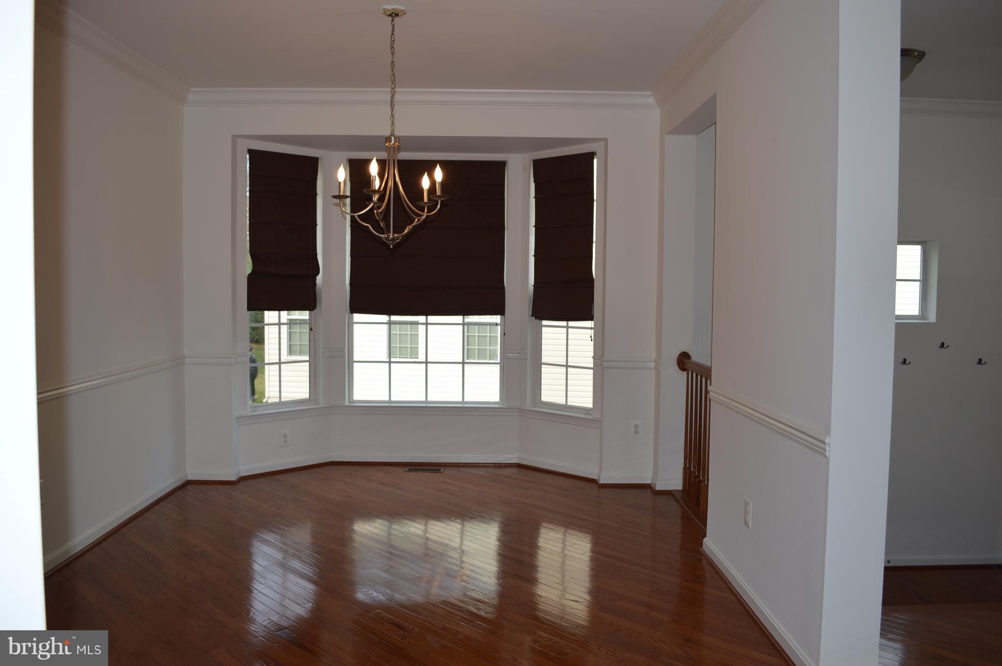 6500 Clarington Road Baltimore, MD 21209 - Photo 4 of 30 a view of empty room with wooden floor and fan