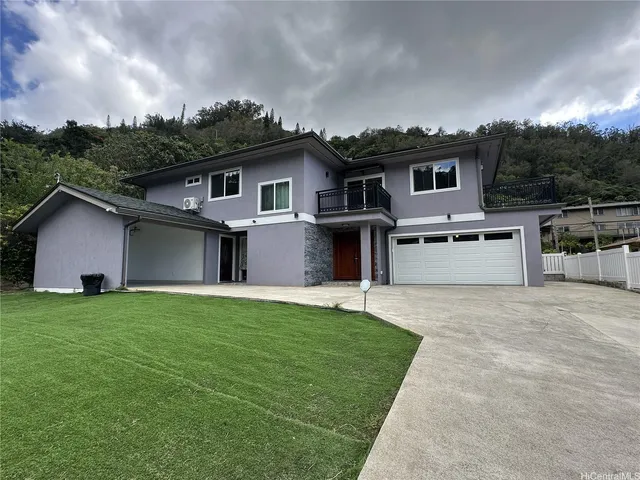 a front view of a house with a garden and yard