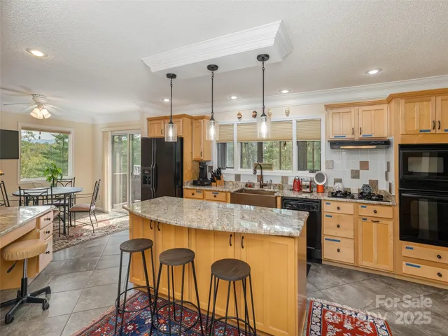 a large kitchen with granite countertop a stove a sink a oven a dining table and chairs