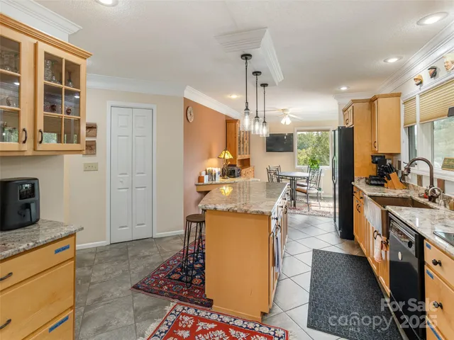 a kitchen with stainless steel appliances kitchen island granite countertop a refrigerator a stove top oven a sink and a dining table with the view of kitchen