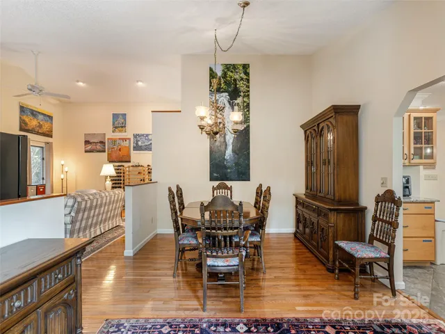a dining room with furniture a chandelier and wooden floor