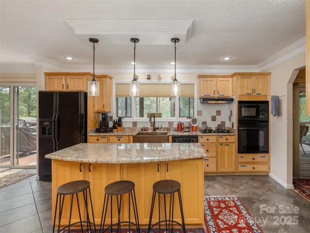 a kitchen with stainless steel appliances granite countertop a refrigerator a sink a stove and island