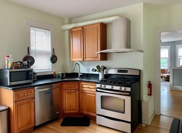 a kitchen with white cabinets and appliances