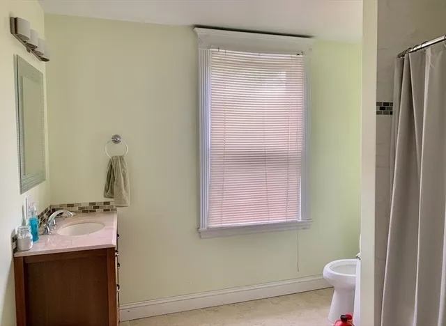 a bathroom with a sink a toilet and a mirror