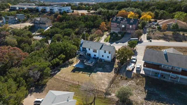 an aerial view of a house with a yard and lake view