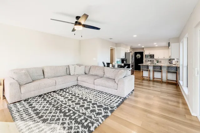 a living room with furniture and kitchen view