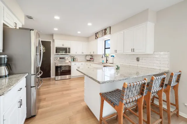 a kitchen with stainless steel appliances granite countertop a sink counter space and cabinets