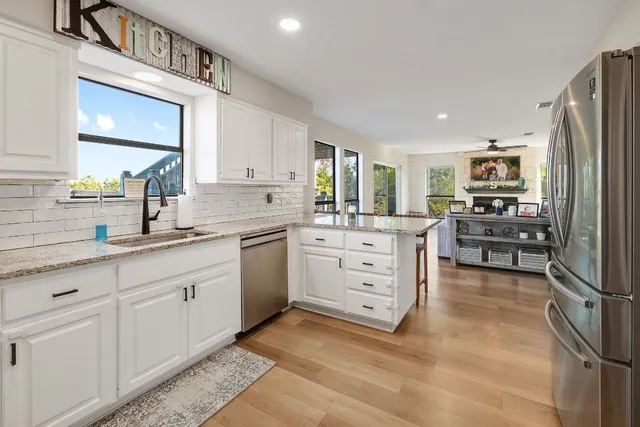 a kitchen with granite countertop a sink stainless steel appliances and cabinets